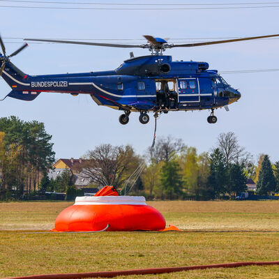 Hubschrauber der Bundespolizei bei der Wasseraufnahme mit einem Au&szlig;enlastbeh&auml;lter "Bambi.Bucket" aus einem Wasserbeh&auml;lter "Fire-Flex Tank".
