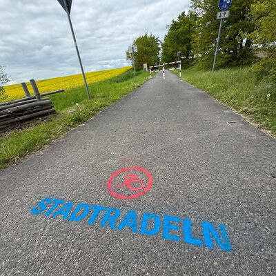 Das Logo der STADTRADELN Kampagne ist mit Kreide auf einen Fahrradweg gemalt.