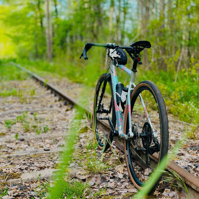 Ein Fahrrad lehnt an einer verlassenen Eisenbahnschiene.