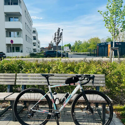 Ein Fahrrad lehnt an einer Bank in einem Wohngebiet.