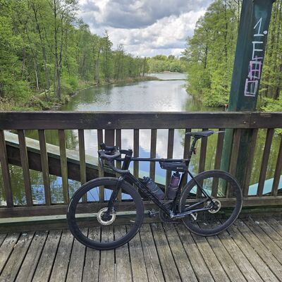 Ein Fahrrad lehnt am Gel&auml;nder einer Br&uuml;cke &uuml;ber einen Fluss.