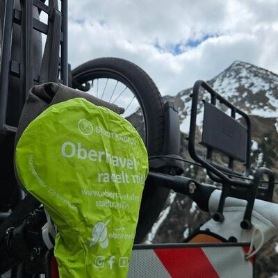 Ein Fahrrad steht vor einem schneebedeckten Berg.