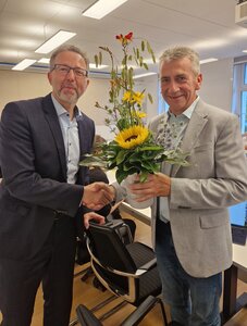 Zwei M&auml;nner in Anz&uuml;gen reichen sich die H&auml;nde zum H&auml;ndedruck. 